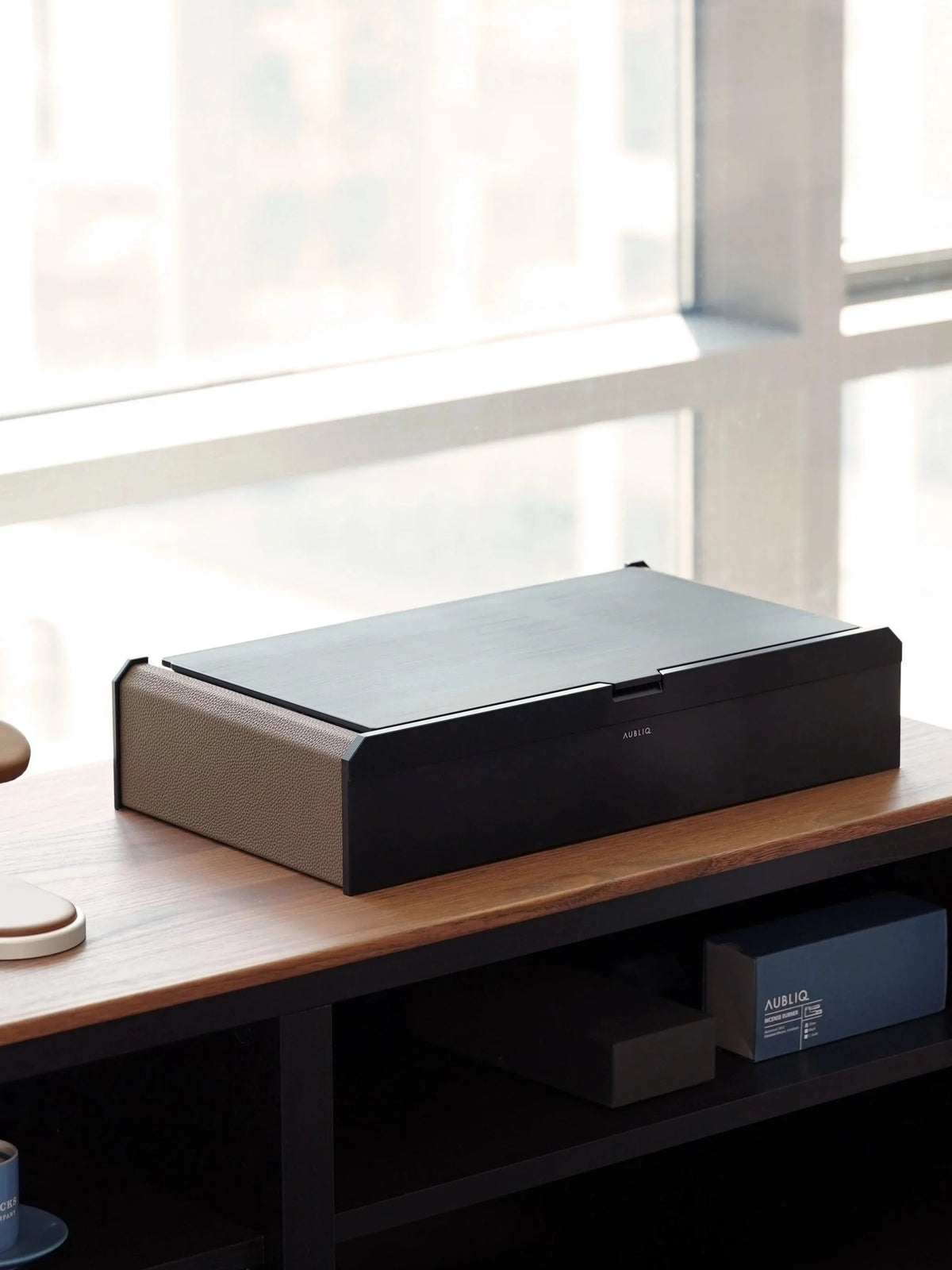Aubliq Attention black aluminium and brown leather watch box on a sideboard